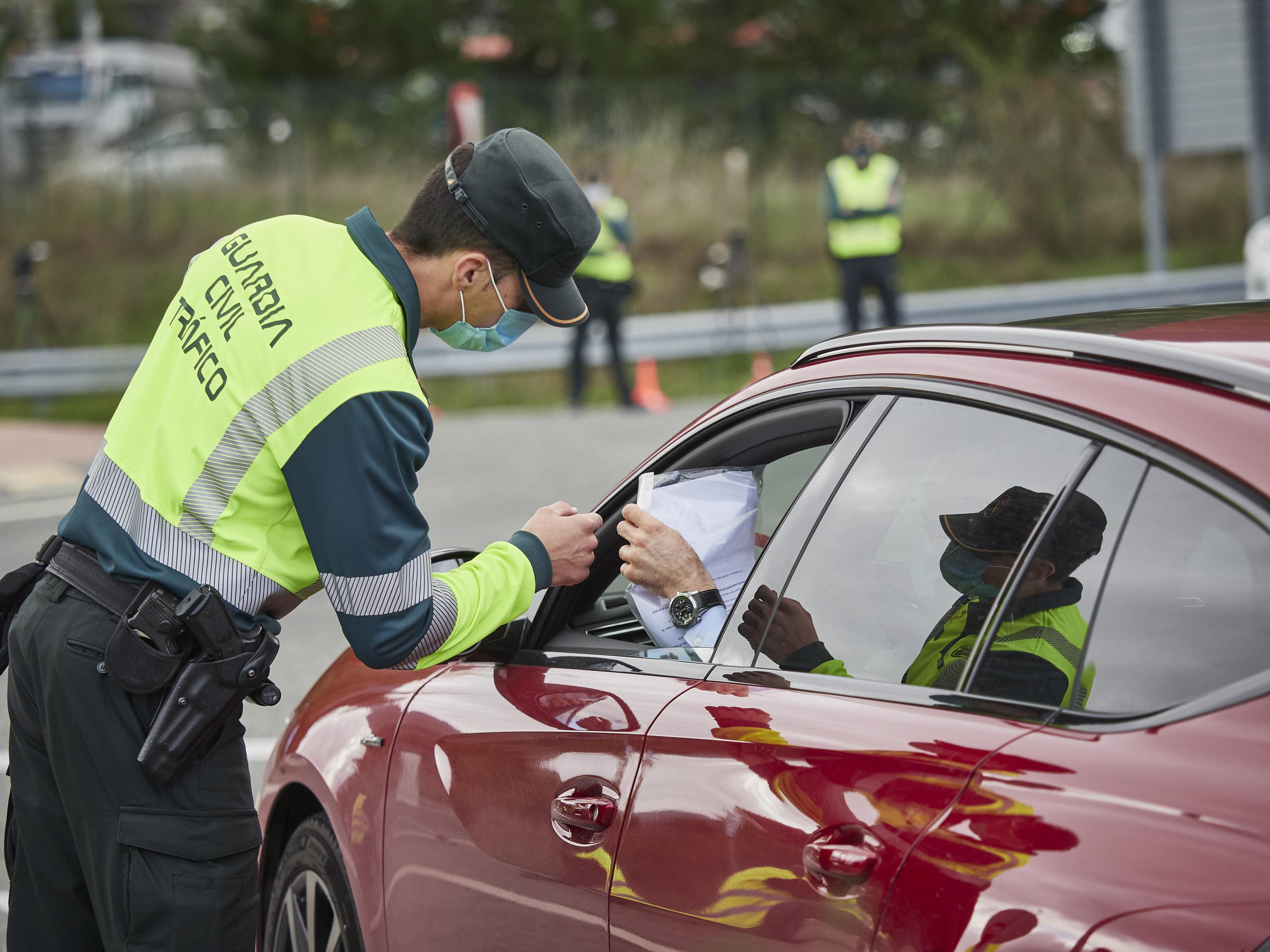 Un agente de la Guardia Civil de Tráfico comprueba la documentación de un conductor en un control policial en la frontera entre Navarra y Álava. EP.