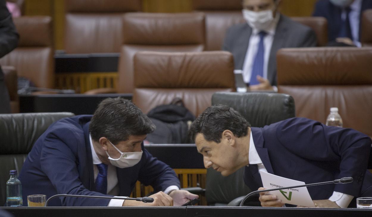 El presidente de la Junta de Andalucía, Juanma Moreno (d), conversa con el vicepresidente de la Junta, Juan Marín (i), durante la sesión de control al gobierno 